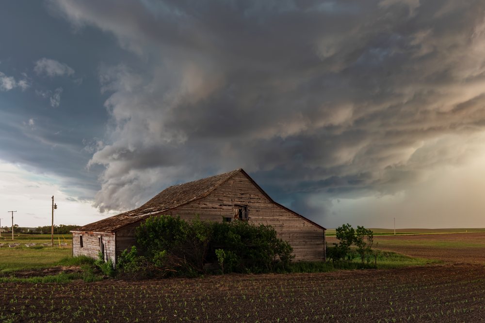 Old Barn under dark Storm Clouds over a rural field during Storm Chasing, Weather, Environmental, Wood, South Dakota, USA.
