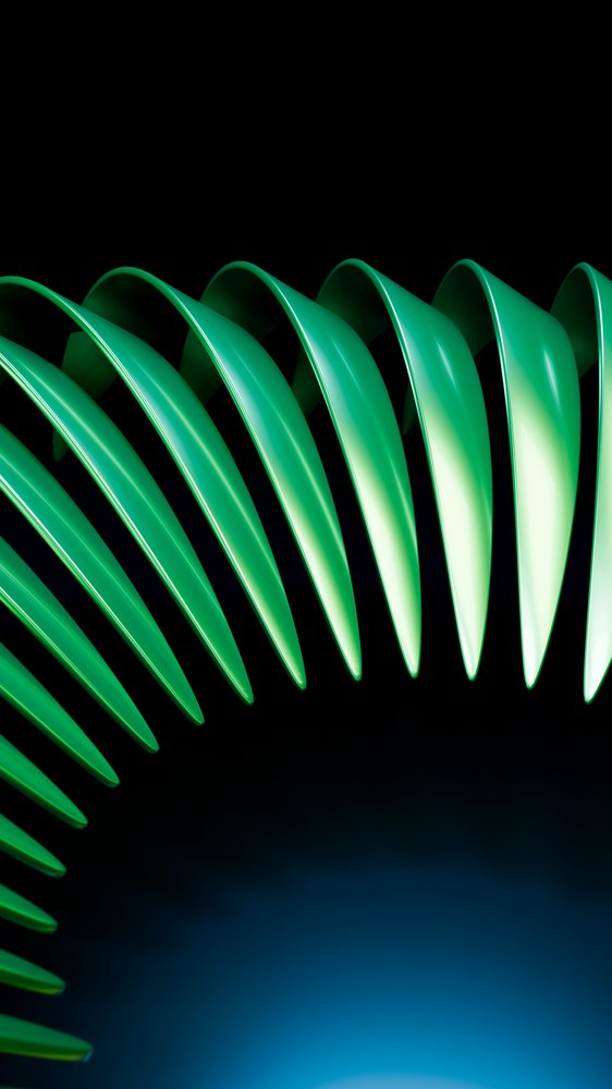 Close-up of spiral green plastic coils with reflective surfaces against a black background with blue light glow.