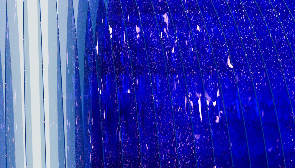 blue glass panes with raindrops on a modern building facade reflecting light.
