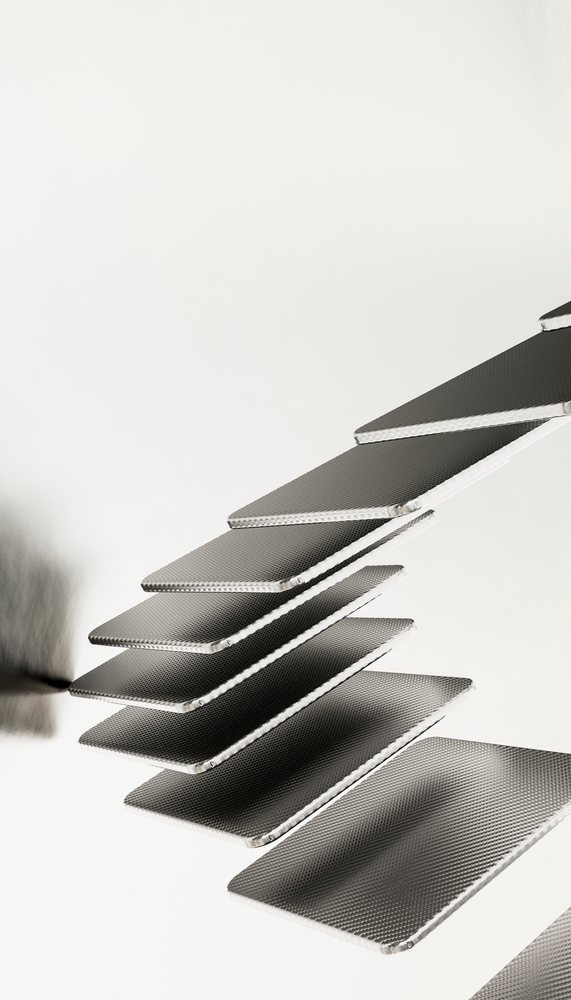 Metallic floating stair steps form a sleek minimalist modern staircase in a monochrome indoor architectural setting.