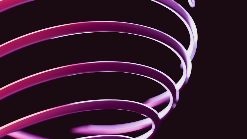 Close-up of a glowing metallic spiral coil with purple and pink light against a dark background.