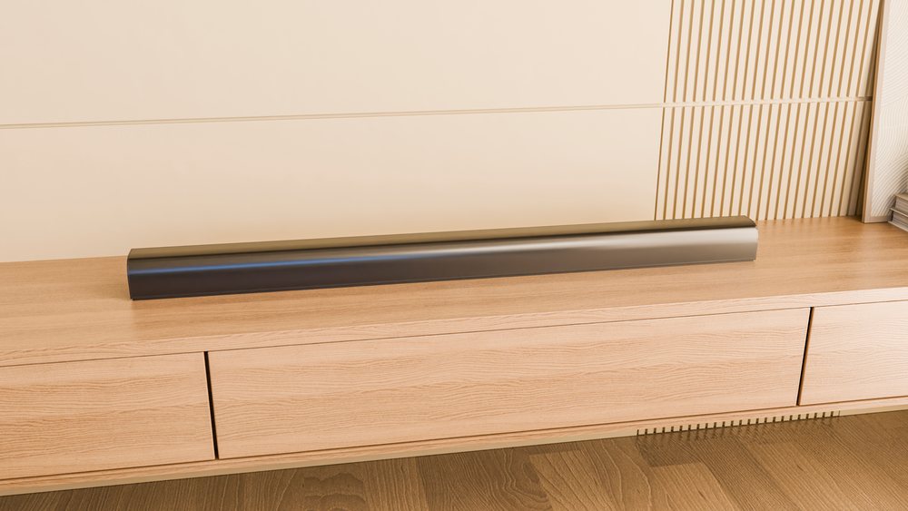 Soundbar placed on a wooden cabinet surface within a modern indoor interior setting.