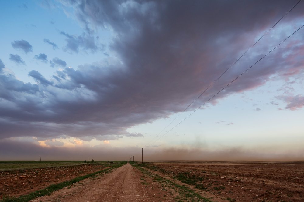 Dust Storm approaching Dusk over a flat rural field on the Great Plains, Post, Texas, USA.