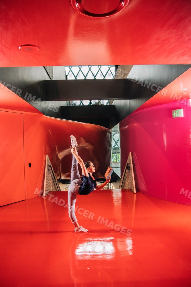A woman stretches and reads a book inside a Seattle public library