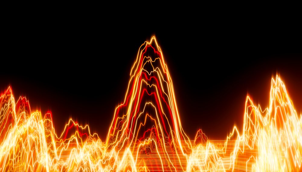 Light waves with glowing orange and red lines forming abstract peaks and energy patterns on a dark background.