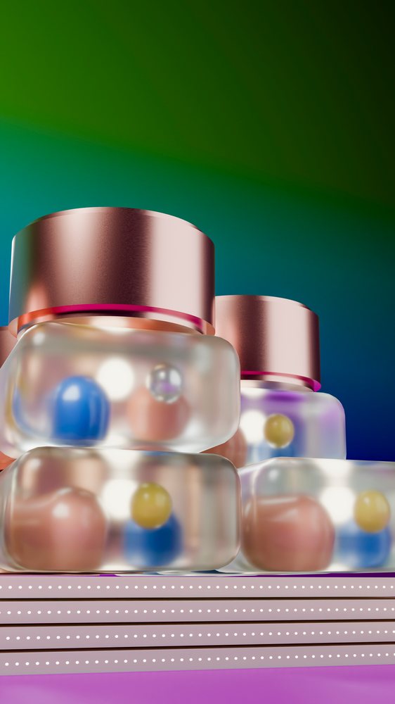 Colorful blue, yellow, and pink spheres inside transparent glass jars with metal lids stacked on a pink table under studio lighting.