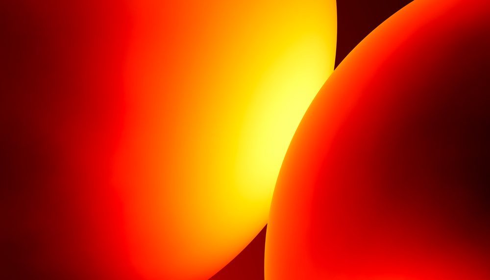 An abstract digital image featuring smooth rounded shapes with a glowing red, orange and yellow color gradient.