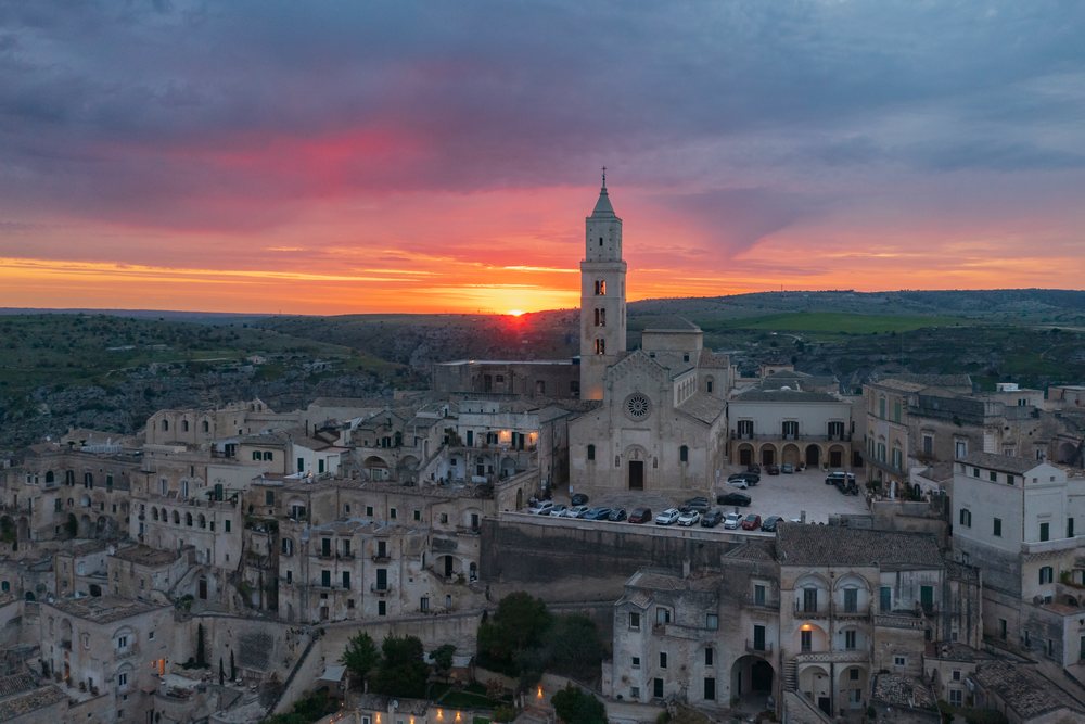 Dawn illuminates the historic cathedral and densely built stone cityscape on the hillside of, Matera, Basilicata, Italy.