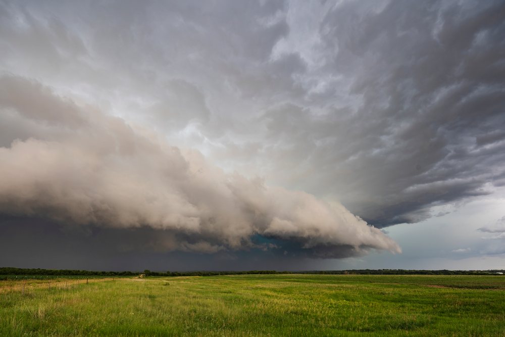 Supercell storm forming over a green grassy field, in the Great Plains region, Weather, Environmental Issues, Storm Chasing, Waterville, Kansas, USA.