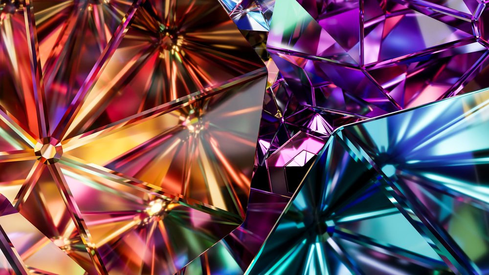 Closeup of colorful faceted gemstones sparkling with vibrant red, blue, purple, and yellow hues in a detailed pattern.