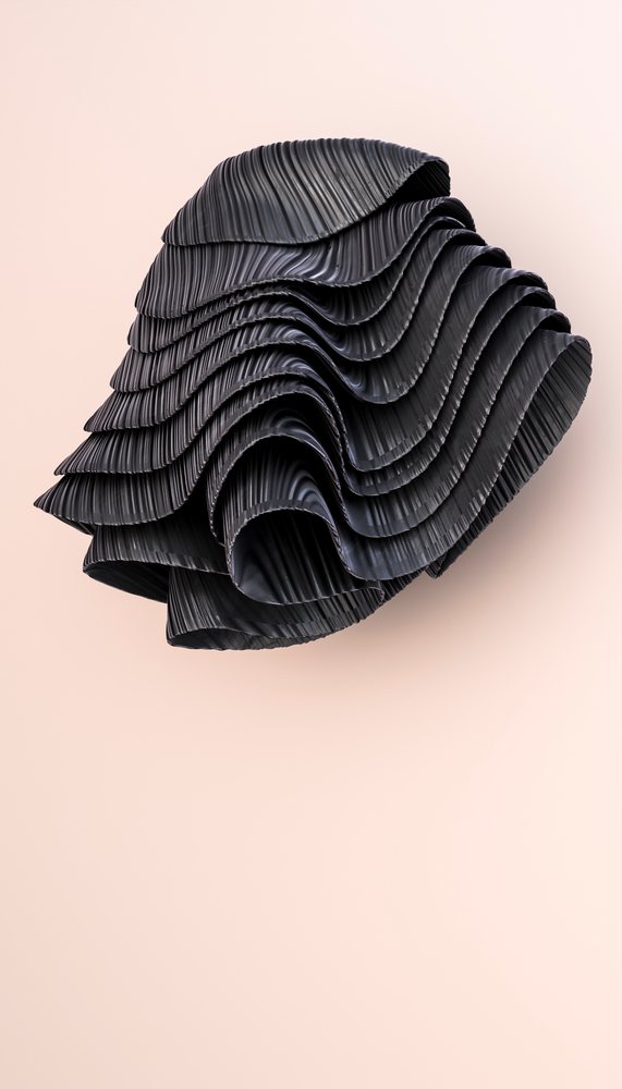 Black abstract sculpture with wavy folded texture and curved ridges isolated on a light background in vertical composition.