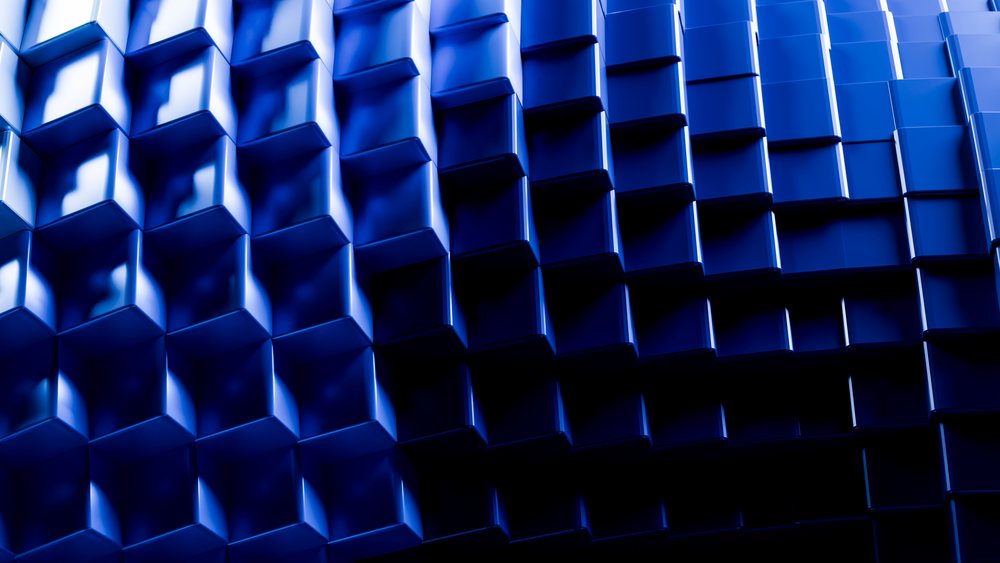 Blue 3D cubes form an abstract geometric pattern with reflective surfaces and shadows.