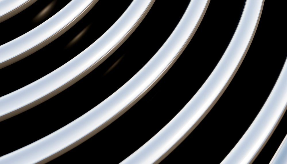 Close-up view of curved shiny metal tubes arranged in parallel lines.