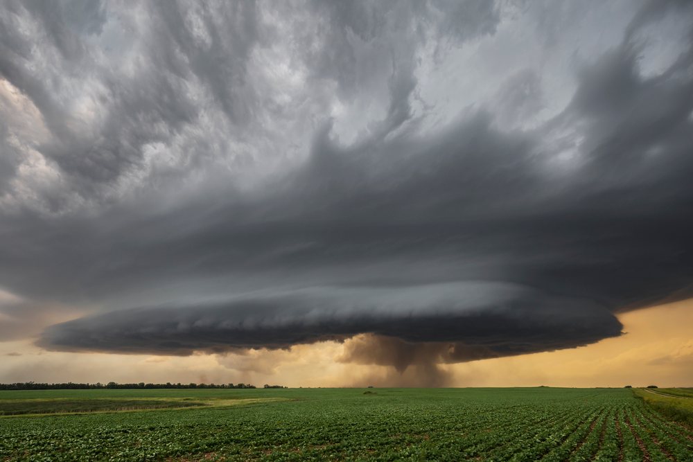 Supercell storm with a Descending Tornado under Kelvin-Helmholtz wave cloud formations over a green field, Marion, North Dakota, USA.