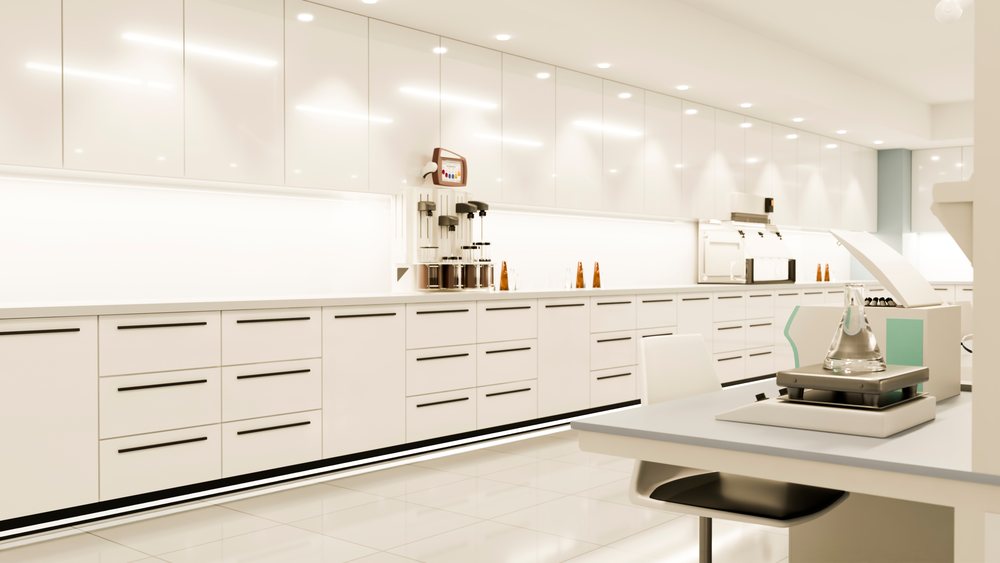 Modern laboratory interior featuring white cabinets, counters with scientific equipment, and a laboratory flask on the worktable.