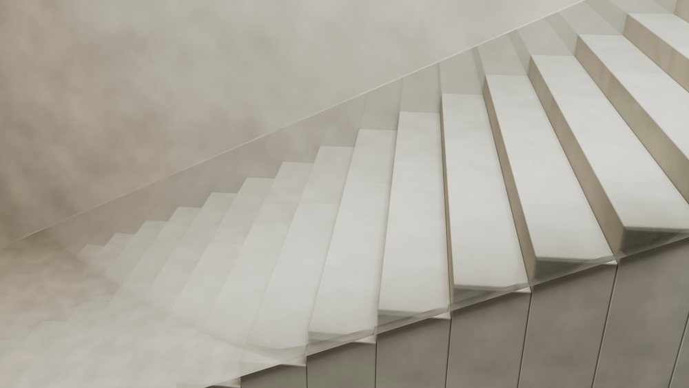 White indoor stairs featuring a minimalist geometric design and smooth concrete surface in a modern interior space.