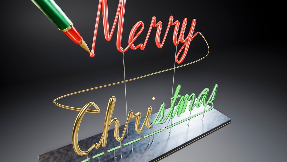 Neon sign with red, green, and gold Merry Christmas letters mounted on a marble base with metal supports against a dark background.