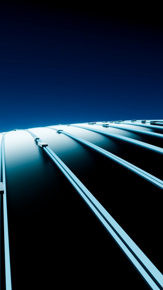 Curved metal roof structure with blue sky background.