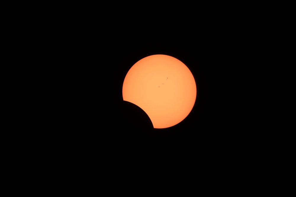 Solar eclipse showing the moon partially covering the sun with visible sunspots over, Los Angeles, USA.