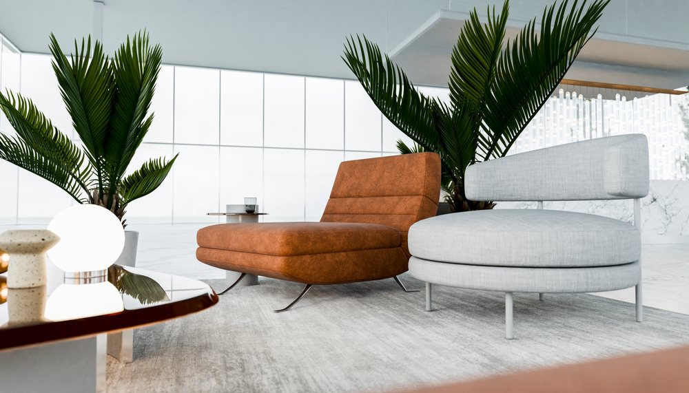 Two modern lounge chairs with palm plants and a round coffee table in a bright, spacious interior with large windows and marble flooring.