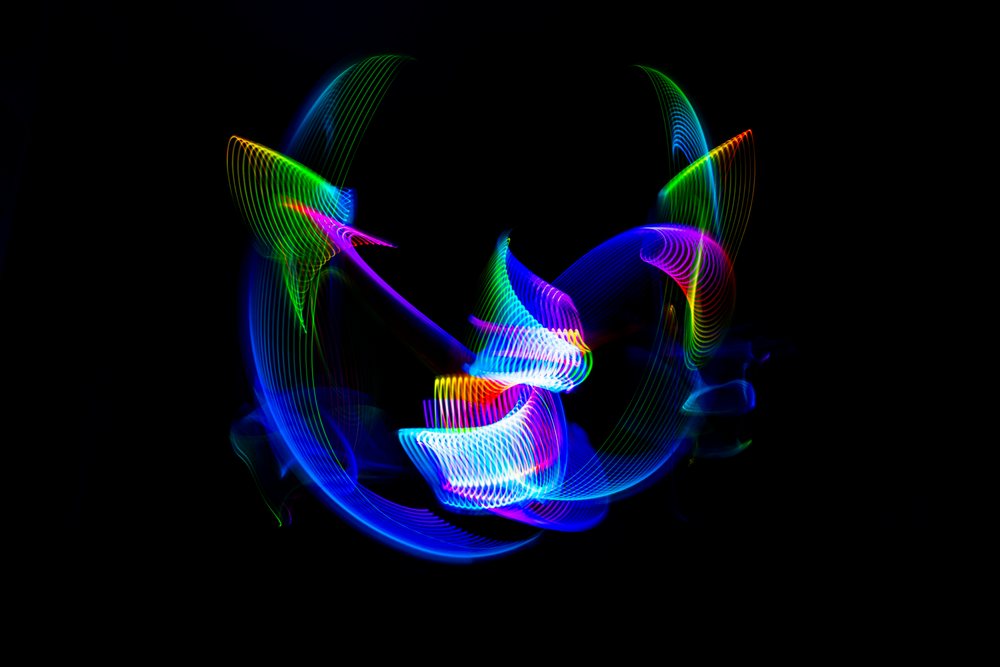 Colorful multicolor light trails created with light painting technique on a black background.