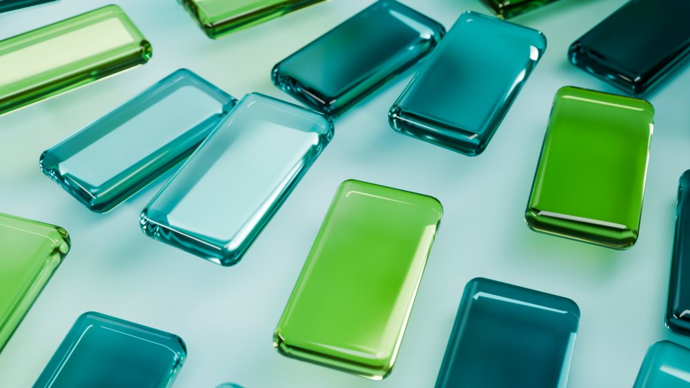 Colorful green and blue rectangular glass blocks arranged on a smooth surface under soft lighting.