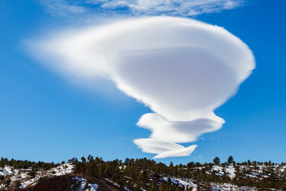 Lenticular Cloud formation above snow-covered High Atlas Mountains, Morocco under blue sky, Lifestyle, Landscape, Culture, Telouet.