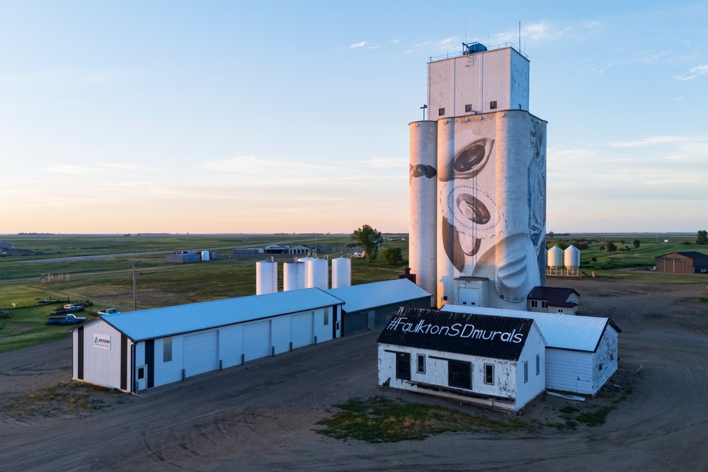 Large grain silo painted with a mural by Guido van Helten at a farm at sunset, Storm Chasing, Weather, Environmental, Faulkton, South Dakota, USA.
