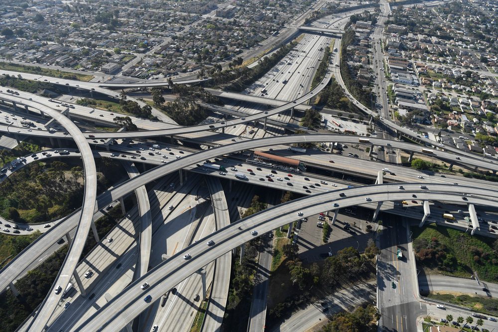 Aerial view of a highway interchange with multiple freeway overpasses and traffic surrounded by residential neighborhoods, California, Long Beach, USA.