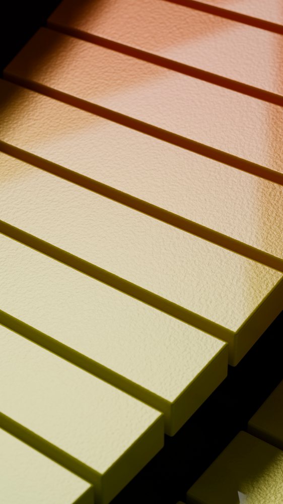 Close-up of yellow and black piano keys showing texture and reflection on the instrument surface.