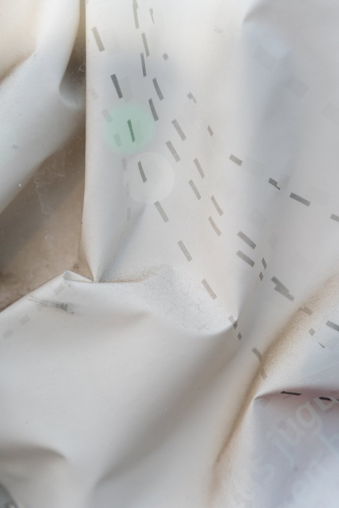 White wrinkled material with a dashed line pattern and soft shadows forms a textured background, texture, abstract texture, wallpaper, Spain.