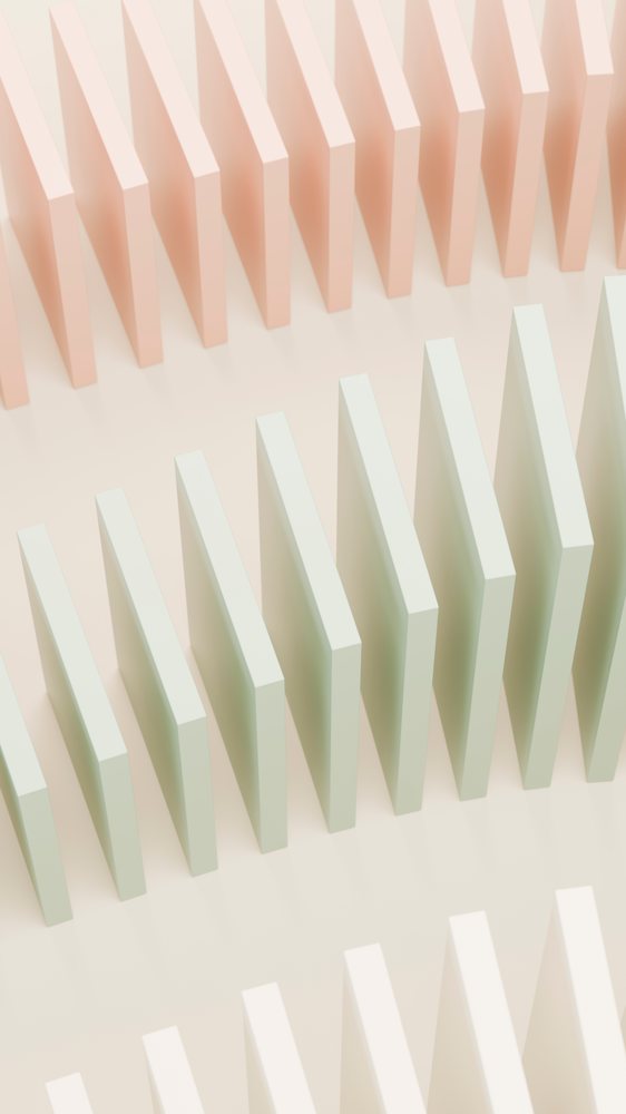 Rows of standing pastel green and pink dominoes arranged in an abstract pattern on a pale background.