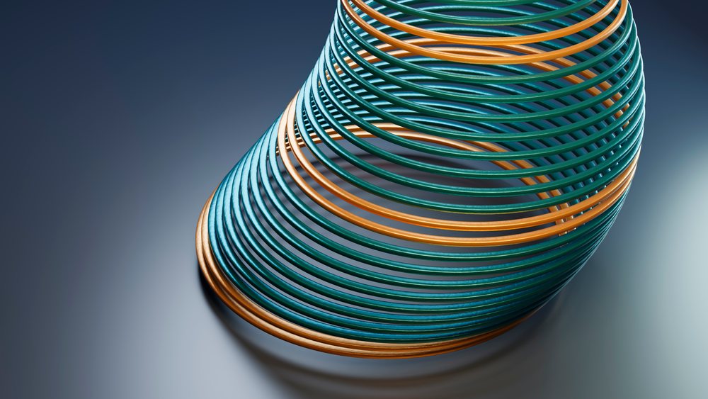 Colorful blue and orange slinky coil spring toy bending on a smooth surface with an abstract background.