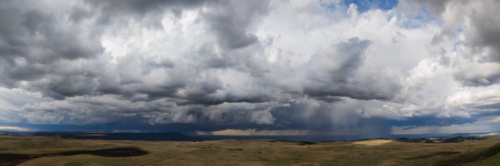 Storm clouds and rain showers gather over the open grassland and mesa landscape of Johnson Mesa in New Mexico, Stoem Chasing, Weather, Environment, USA, Tornado Alley, Great Plains.