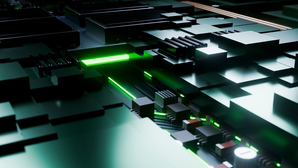 Close-up of a black circuit board with glowing green light highlighting electronic components and microchips.