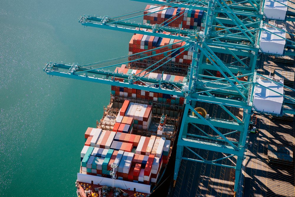 Container ship is being loaded with multicolored shipping containers at cranes in a busy port located in Long Beach, lifornia, Port of Long Beach, CA, USA.
