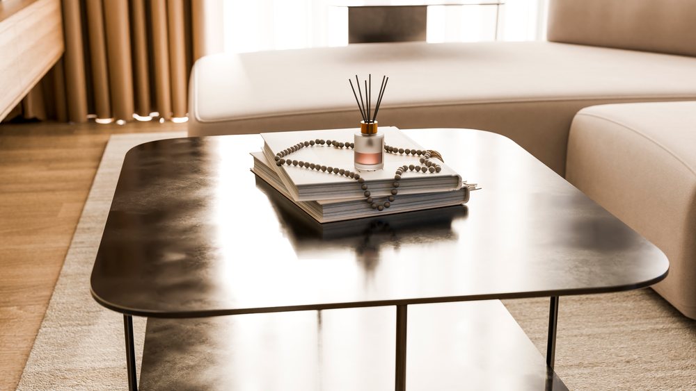 Modern living room coffee table with stacked books, aroma diffuser, and bead garland accentuating a cozy indoor setting.