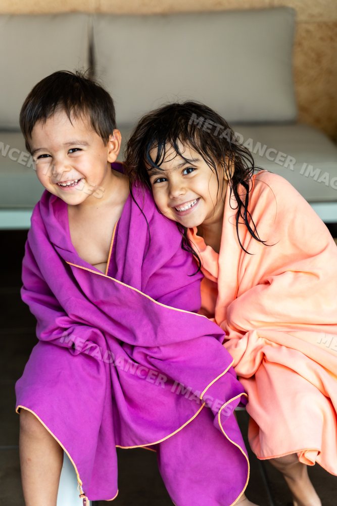Two smiling white children wrapped