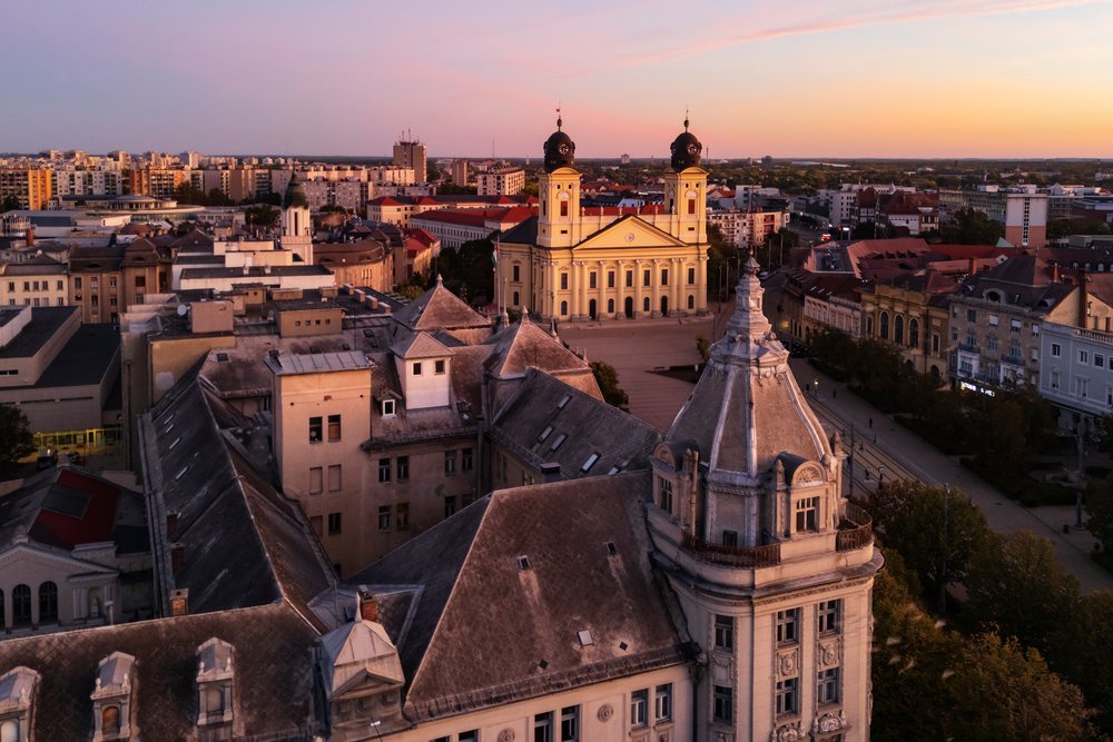 View at Dawn of the Reformed Church with two towers and surrounding Art Nouveau/Secessionist Buildings at Kossuth Square, Cityscape, Débrecen, Hungary.