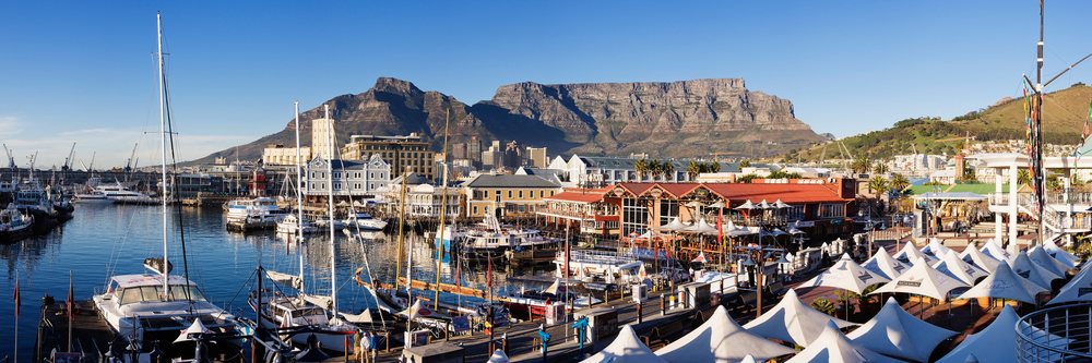 Victoria and Alfred Waterfront harbor with boats docked at the marina and Table Mountain visible in the background, Cape Province, South Africa.