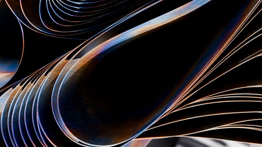 Stacked curved metal sheets with textured surfaces and shiny edges against a dark background.