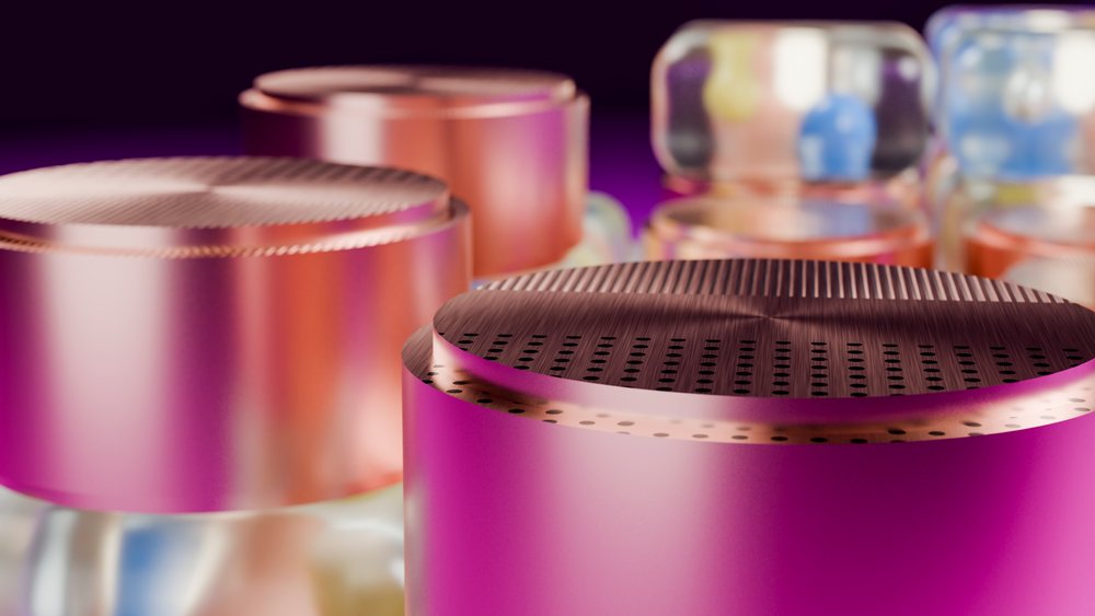 Close-up of purple and pink metallic cylindrical caps with textured, reflective surfaces in an abstract arrangement.