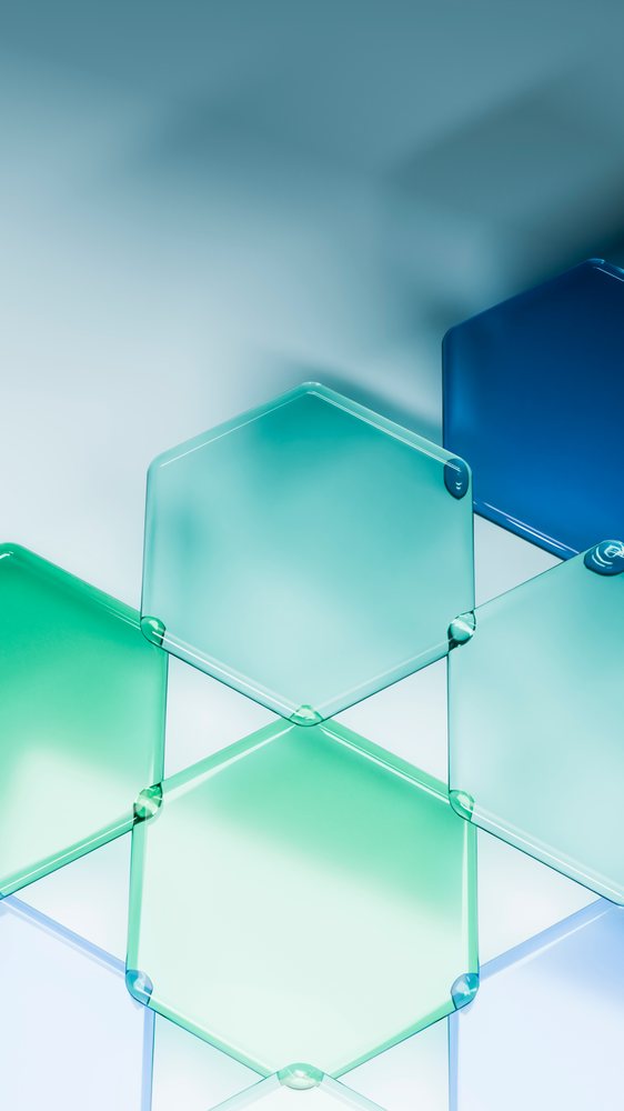 Transparent blue and green glass hexagons form a modern geometric pattern on a smooth surface.