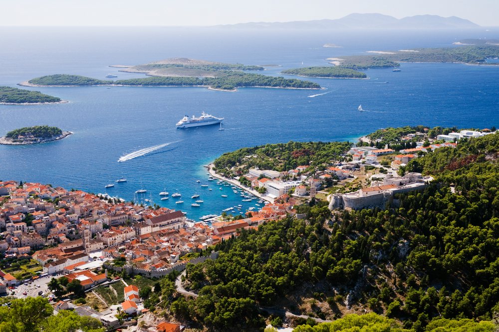 Aerial view of Hvar island and harbor with boats, cruise ship, and Mediterranean coastline, Croatia.