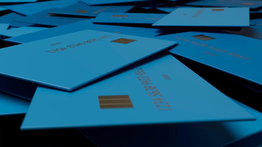 Multiple blue credit cards with visible EMV chips are spread out overlapping in a close-up view highlighting payment technology.