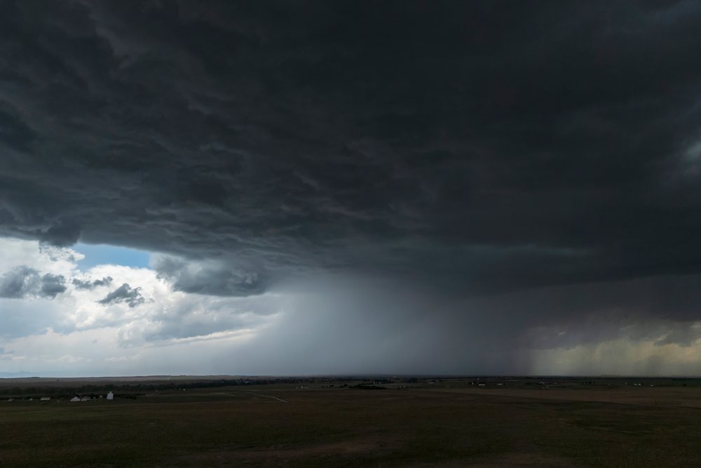 Storm clouds with a rain shaft over an open Great Plains landscape, Colorado under a dark overcast sky, Storm Chasing, Weather, Environmental, Byers, USA.