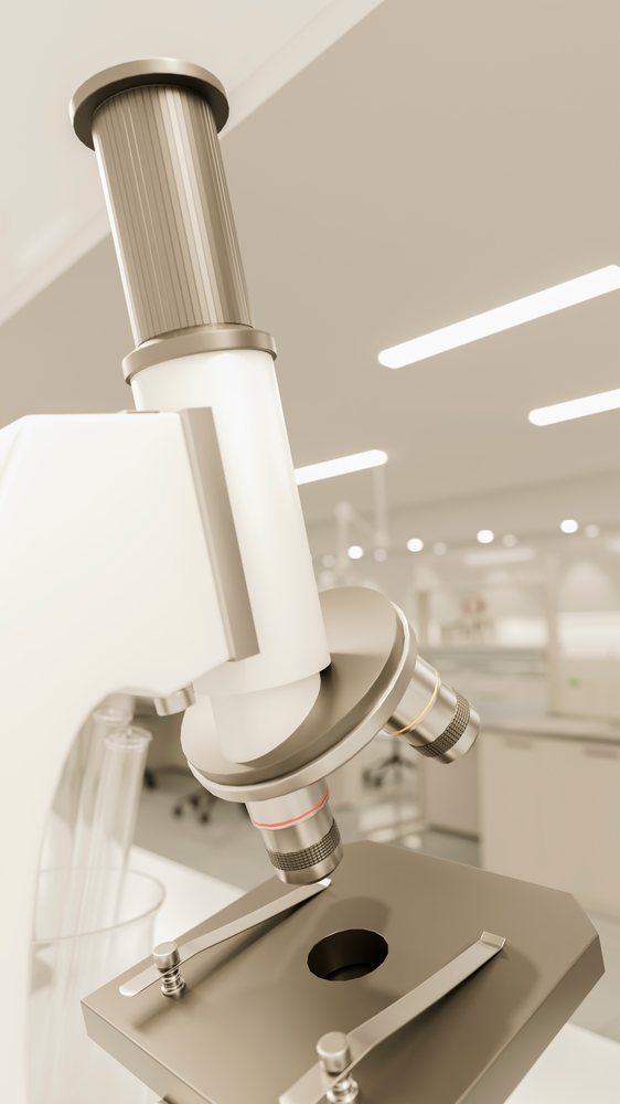 Microscope with objective lenses and test tubes in a modern laboratory environment.