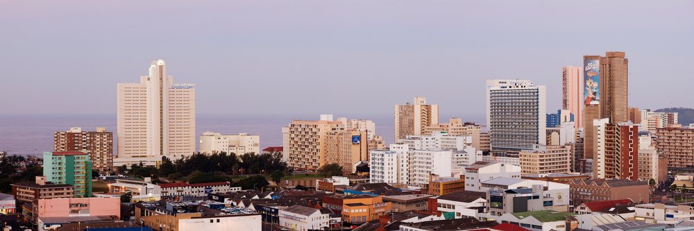 Sunset over Durban's cityscape featuring highrise buildings and the ocean, Kwazulu Natal, South Africa.