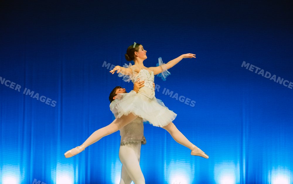 Ballet dancers perform a graceful lift during a stage performance