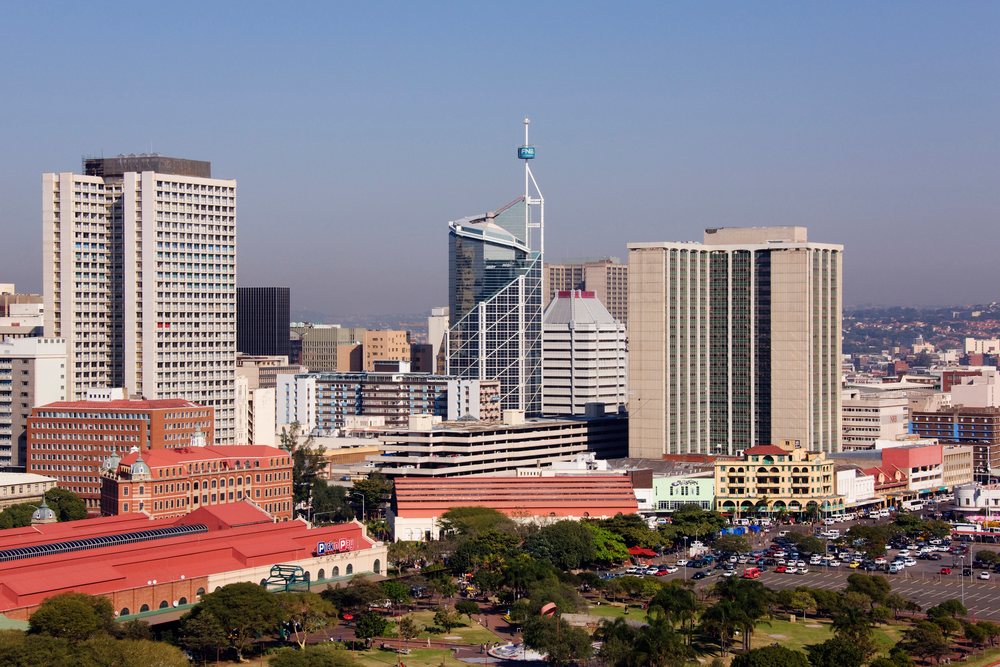 Durban skyline featuring high-rise buildings and an urban park, under a clear blue sky, KwaZulu Natal, South Africa.